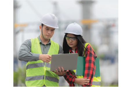 2 people in safety vest looking at tablet by powerlines